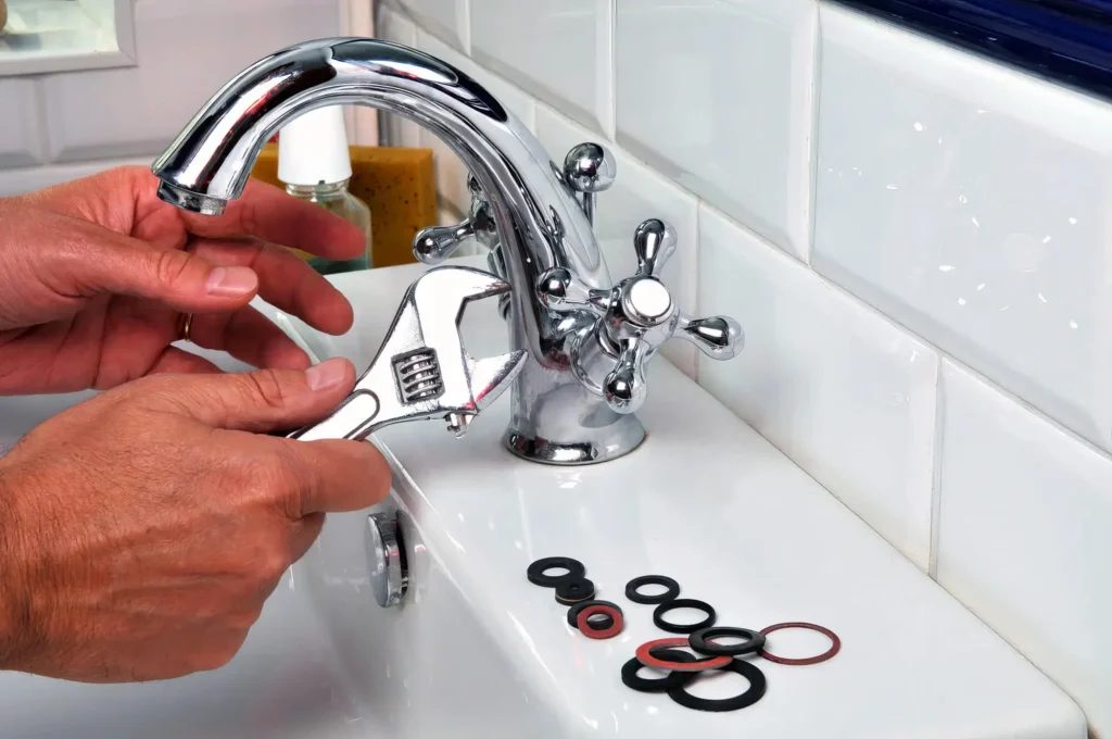 Plumber performing maintenance on a bathroom faucet in Lehigh Acres