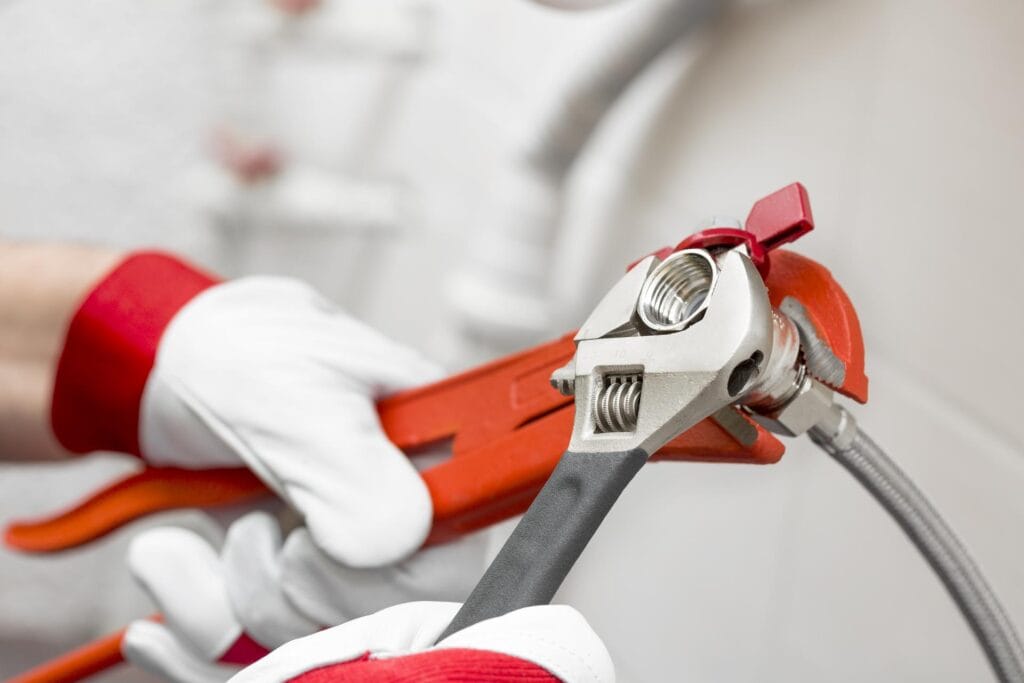 Plumber holding pipe wrenches for an emergency repair in Lehigh Acres