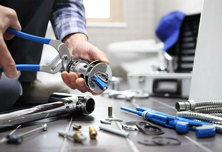 Technician repairing a plumbing fixture with professional tools in Lehigh Acres