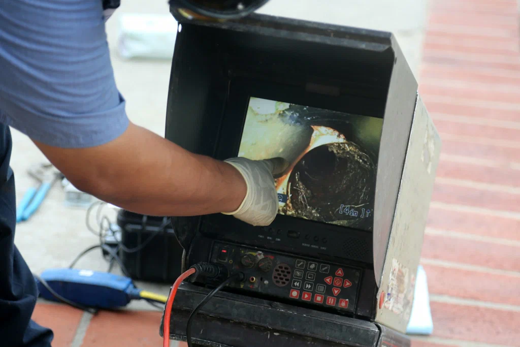 Technician viewing a drain inspection camera in Lehigh Acres